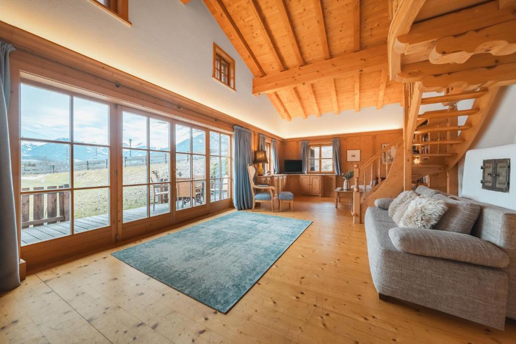 a living room with a couch and large windows at Chalet Ninni in Kitzbühel