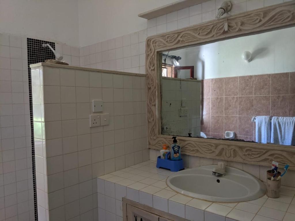 a bathroom with a sink and a mirror at Karibuni Villa - Malindi beach view property in Malindi