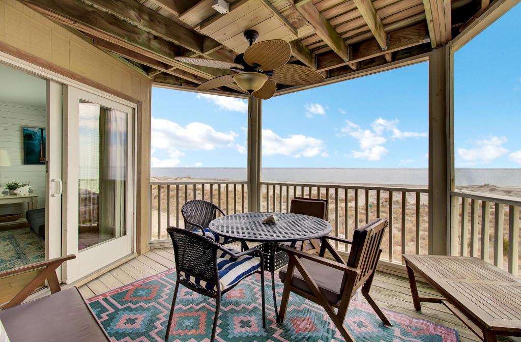 a patio with a table and chairs on a balcony at 204 B Port O Call by AvantStay Beachfront Condo in Isle of Palms
