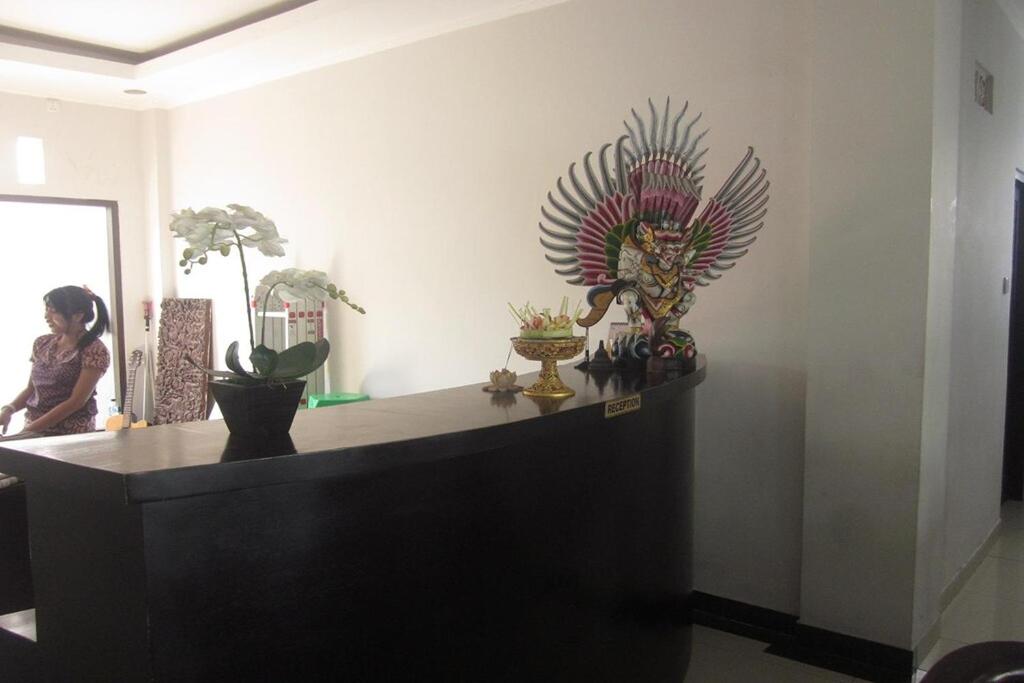 a room with a counter with a statue on it at Hotel Warta Dua in Denpasar