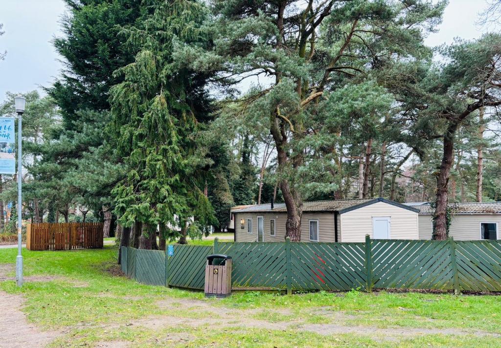 a fence in front of a house with trees at WILD DUCK HAVEN RESORT in Belton