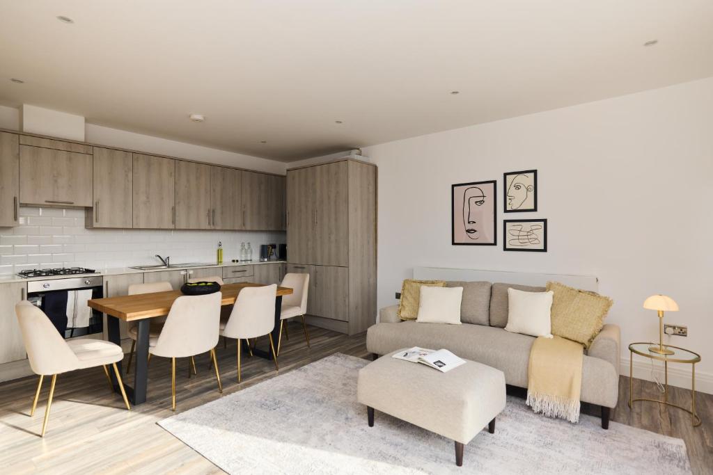 倫敦的住宿－The Harlesden Place - Modern 3BDR Flat with Balcony，客厅以及带沙发和桌子的厨房。