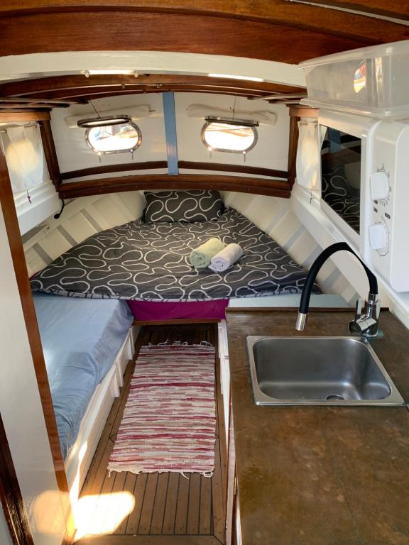 an interior view of a kitchen and a sink in an rv at Lovely wooden boat in Port forum, with AC and two bikes. in Barcelona