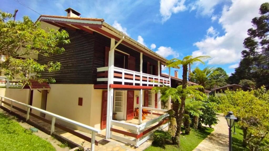 a house with a black and white facade at Pousada das Montanhas in Monte Verde