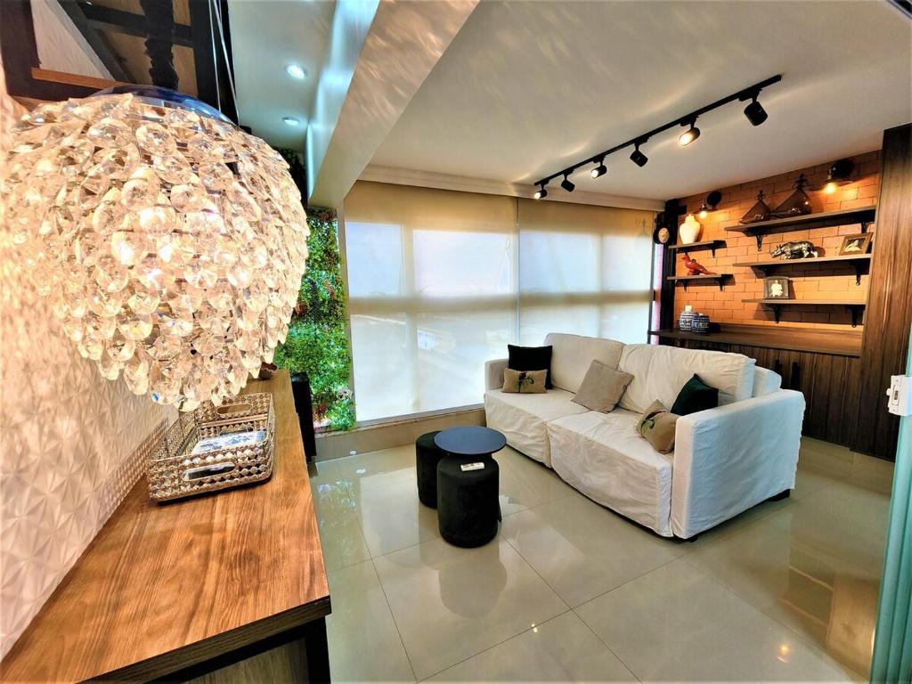 sala de estar con sofá blanco y lámpara de araña en JADE, BLOCO A, APT 1209 · Hotel Jade, 2 quartos, parque sul, vista livre, en Brasilia