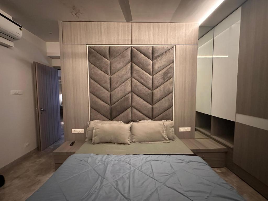 a bedroom with a large bed with a headboard at House of Luxury 8 in Mumbai