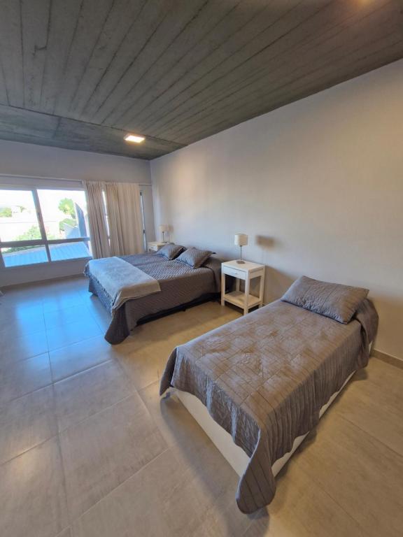 een slaapkamer met twee bedden en een tafel met een lamp bij Austral Lofts in Puerto Madryn
