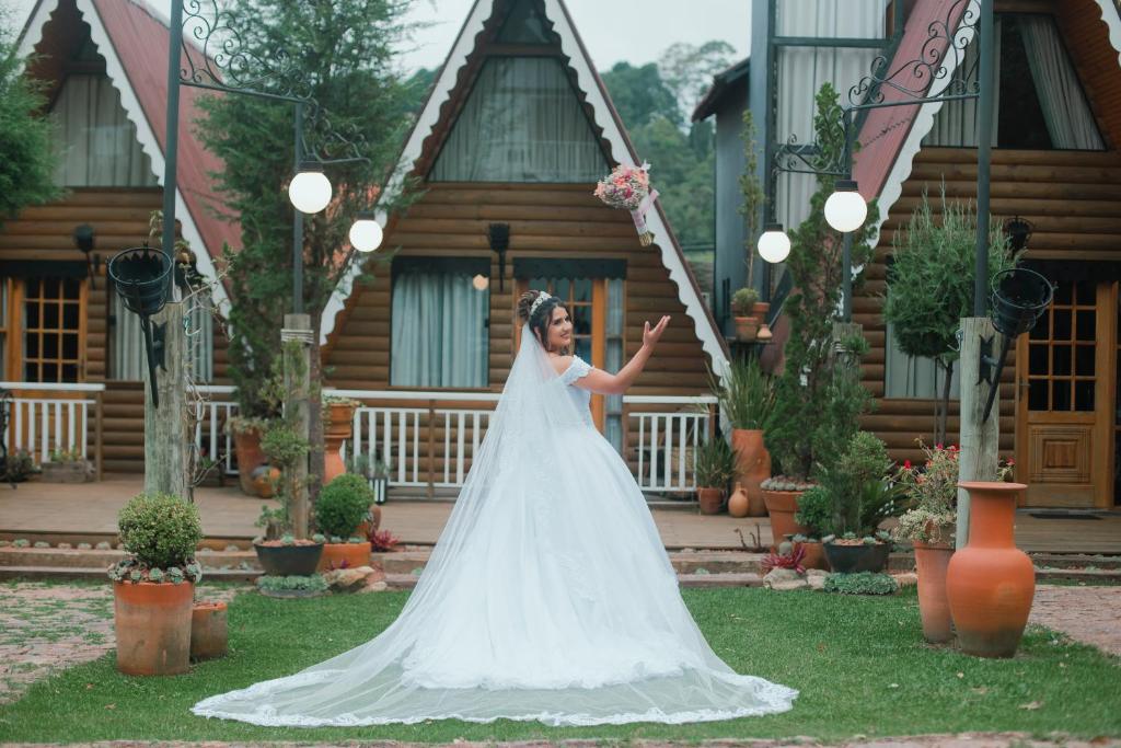 a bride is standing in front of a house at Suítes no Chalé in Campos do Jordão