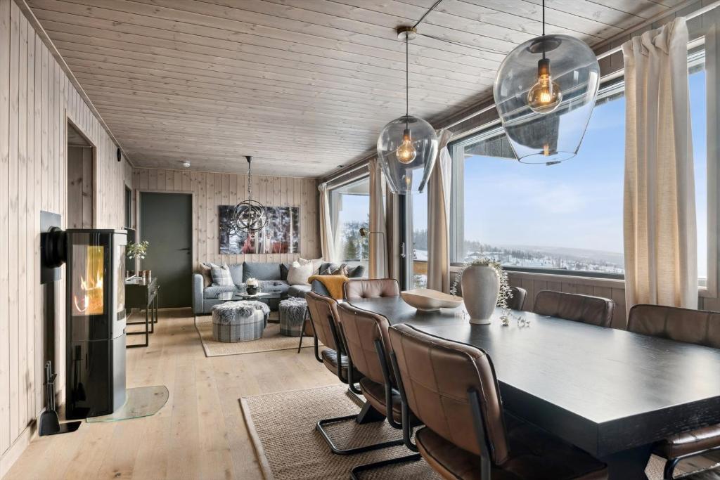 a dining room and living room with a table and chairs at Hafjell Front 8pers, Ski in/out. Downhill Bike in Hafjell