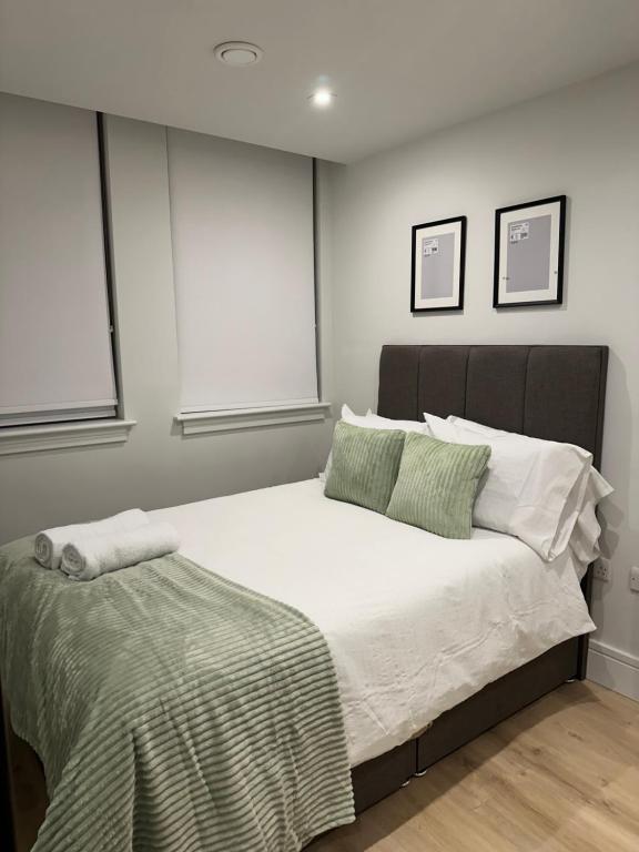 a bedroom with a large white bed with two pillows at Luxury Capella Court in London