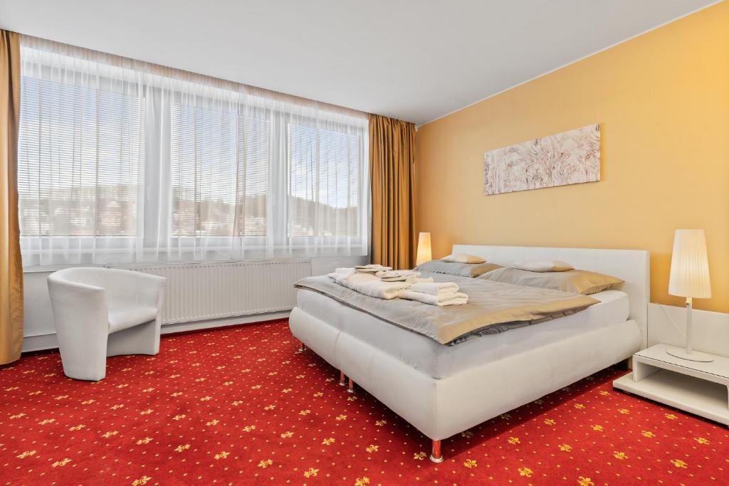 ルハチョヴィツェにあるVila Jiřinkaの赤いカーペットフロアのベッドルーム1室(大型ベッド1台付)