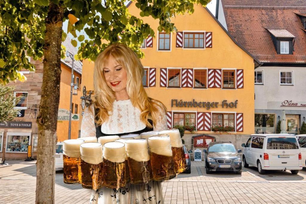 una mujer sosteniendo un montón de barriles de cerveza en Hotel Nürnberger Hof in Altdorf en Altdorf bei Nuernberg