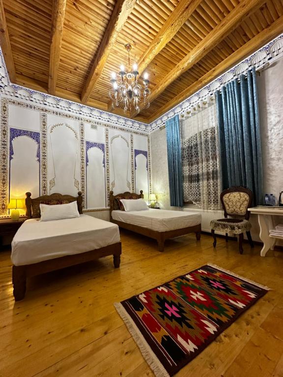 a bedroom with two beds and a chandelier at Central Asia Hotel in Bukhara