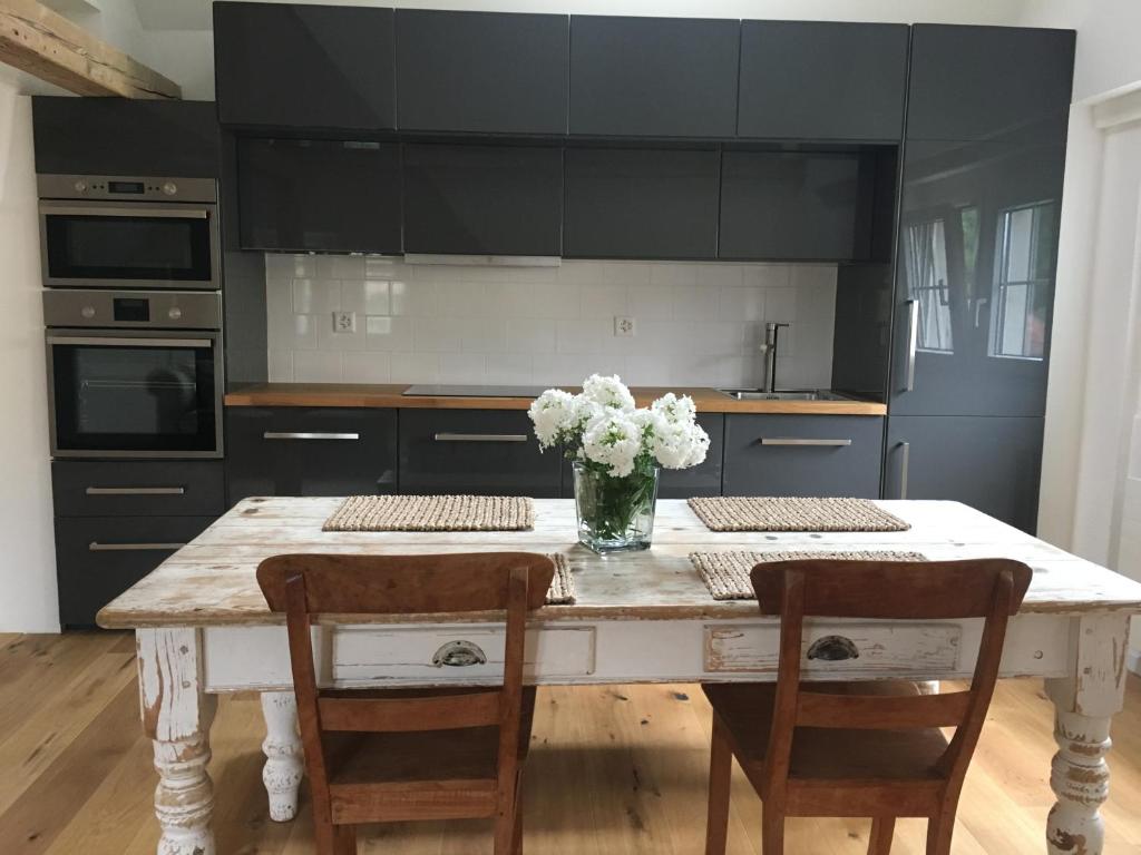 une cuisine avec une table et un vase de fleurs. dans l'établissement Loft Apartment in Central Zug, à Zoug