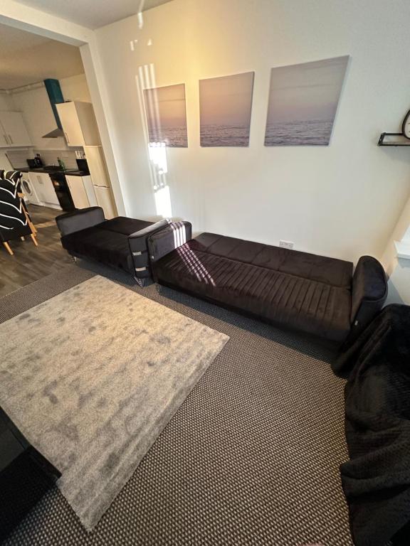 a large couch in a living room with a rug at Cosy 3 Bed Apartment,Free Parking in Birmingham in Birmingham