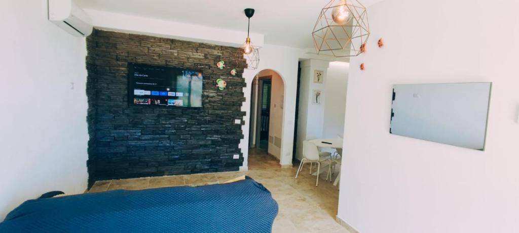 a room with a brick wall and a blue bed at Oasi love & relax in Maratea
