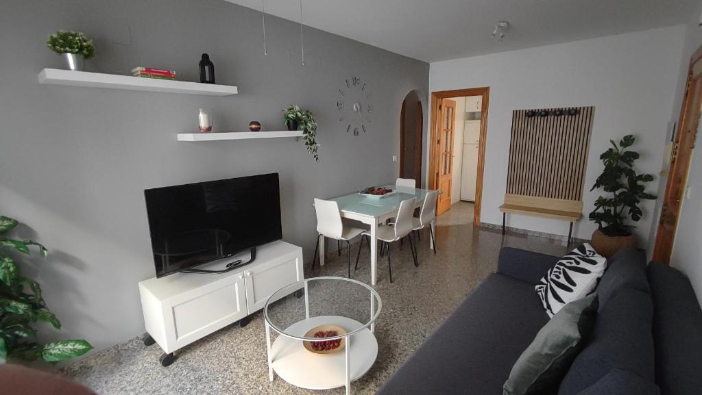 a living room with a couch and a tv and a table at Apartamento VILLASOLETE in Fuengirola