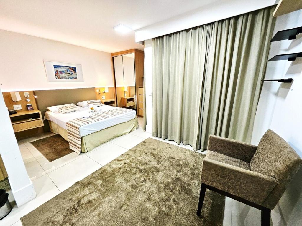 a hotel room with a bed and a chair at Cullinan 1017E · Hotel Cullinan Luxury Premium com varanda in Brasilia