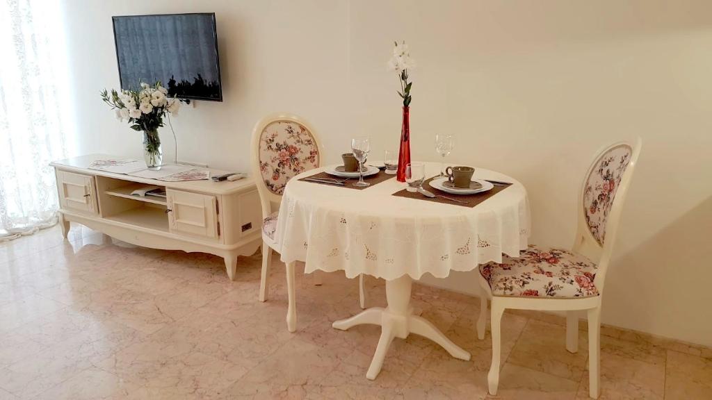 a dining room with a table with two chairs and a table with flowers at Apartments on Kirova in Dnipro