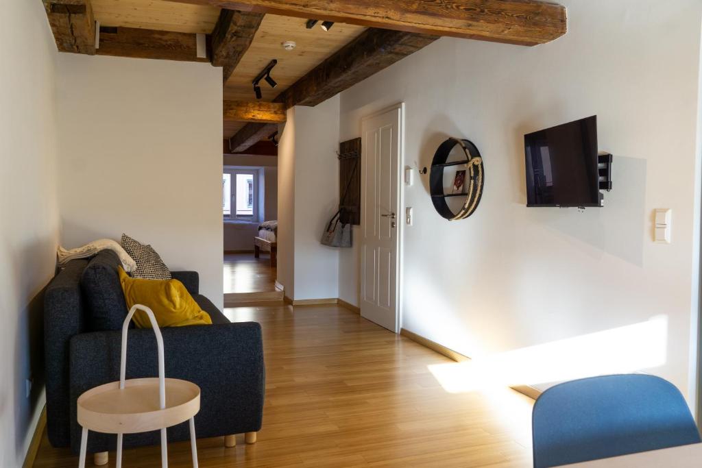 ein Wohnzimmer mit einem blauen Sofa und einem Tisch in der Unterkunft Kleines Schwarzwald-Glück City in Villingen-Schwenningen