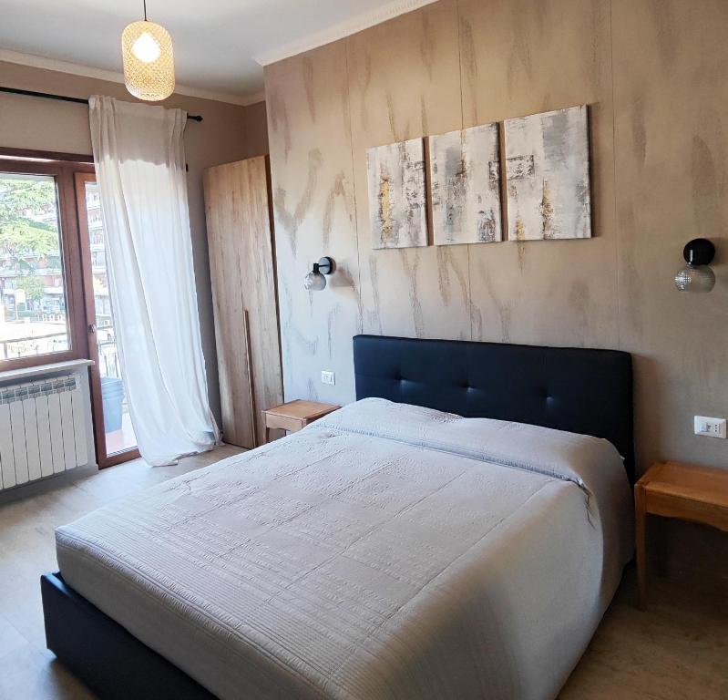 sypialnia z dużym łóżkiem i dużym oknem w obiekcie Doina Guest House w Rzymie