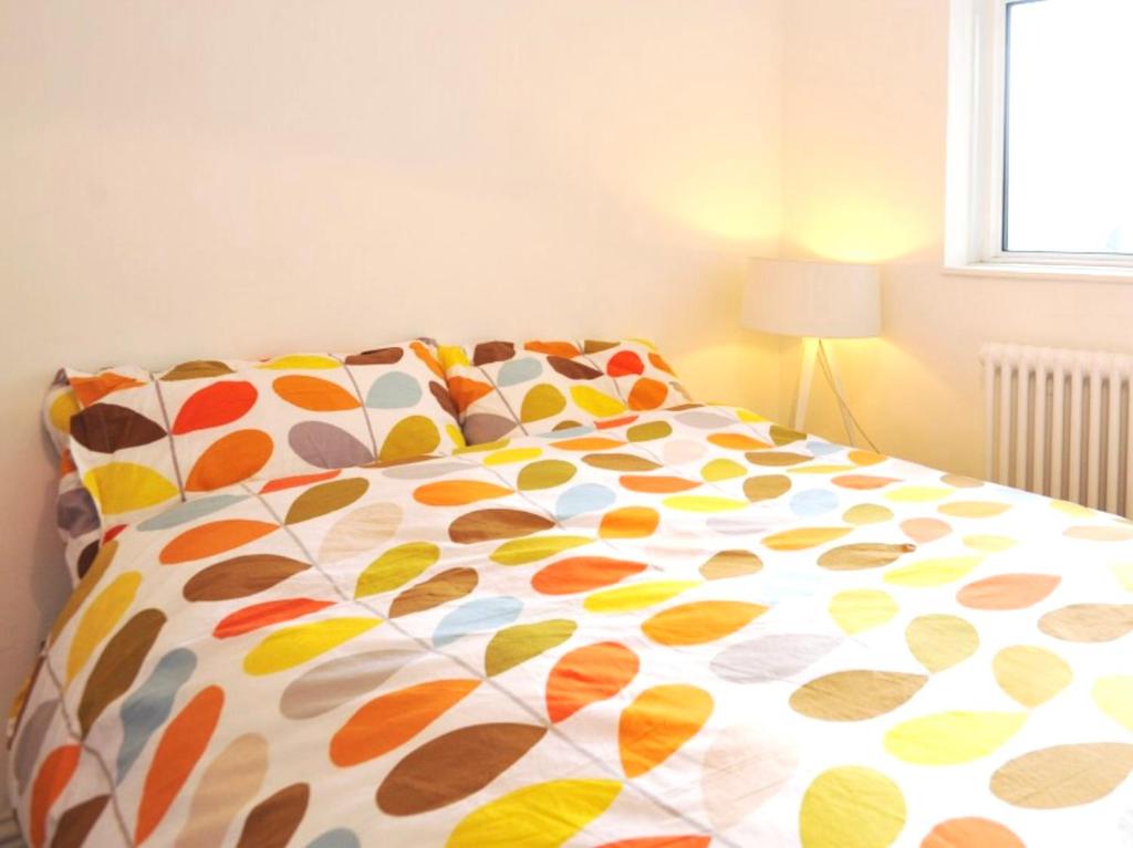a bed with a colorful comforter in a bedroom at Waterloo Central London in London