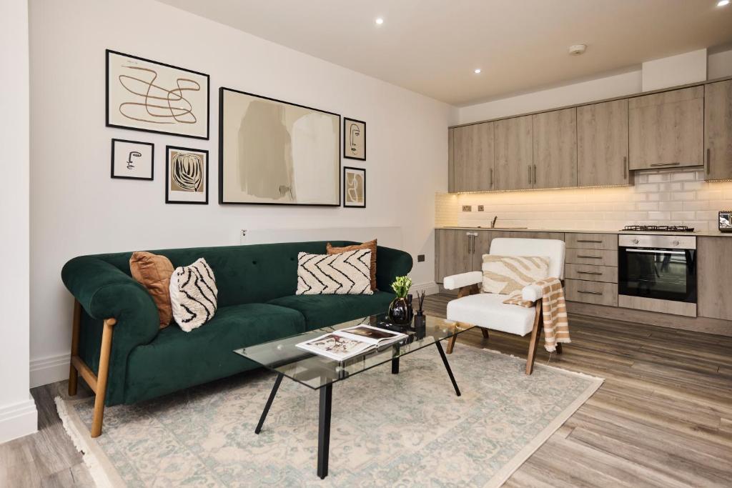 - un salon avec un canapé vert et une table dans l'établissement The Harlesden Hideout - Charming 2BDR Flat, à Londres
