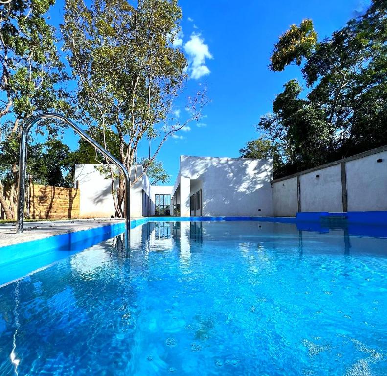 una piscina de agua azul frente a un edificio en SONSOLES HOTEL en Paso de la Patria
