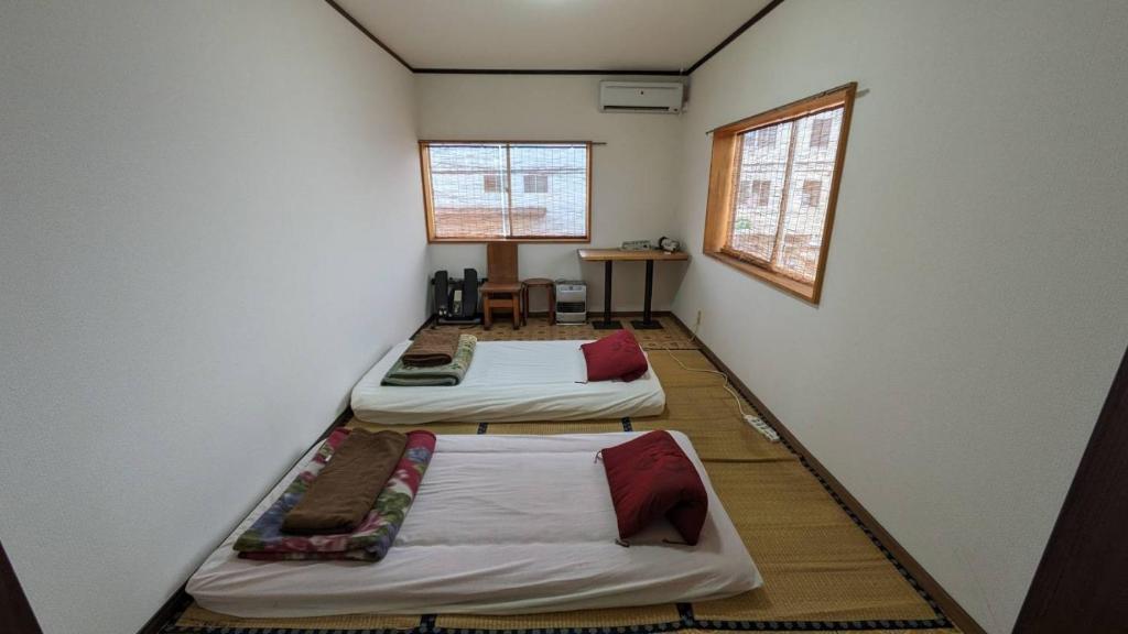 3 camas en una habitación con 2 ventanas en Hamburger restaurant Big foot - Vacation STAY 16266, en Hachinohe