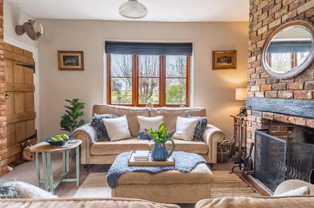 a living room with a couch and a fireplace at Samphire Cottage by Big Skies Cottages in Docking