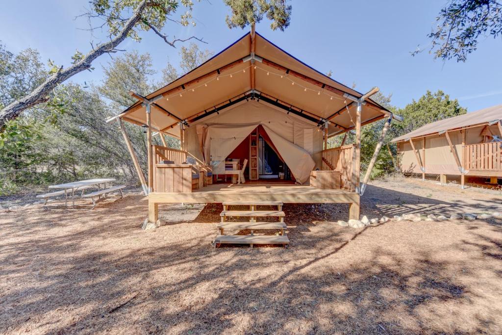 a large tent with a porch in a field at 12 Fires Luxury Glamping with AC #1 in Johnson City