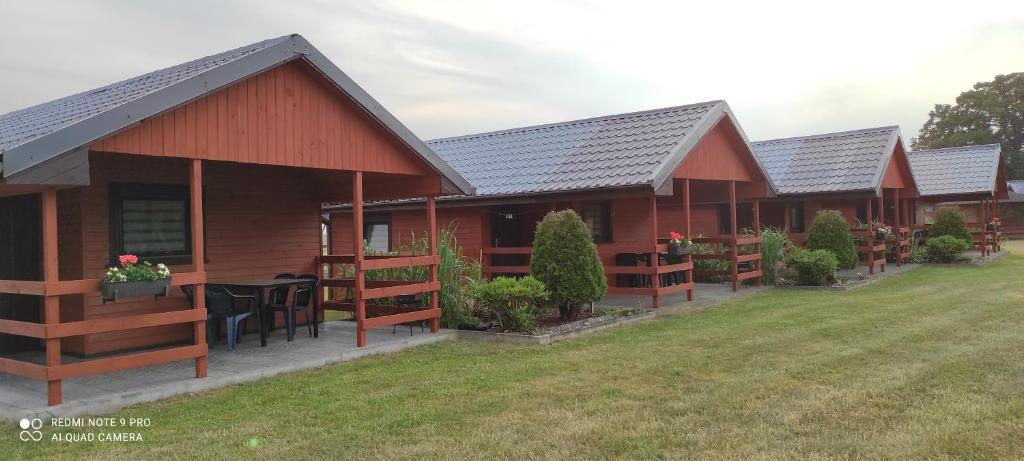 a row of cottages with a table in the yard at Domki letniskowe "DORCIA" in Łeba