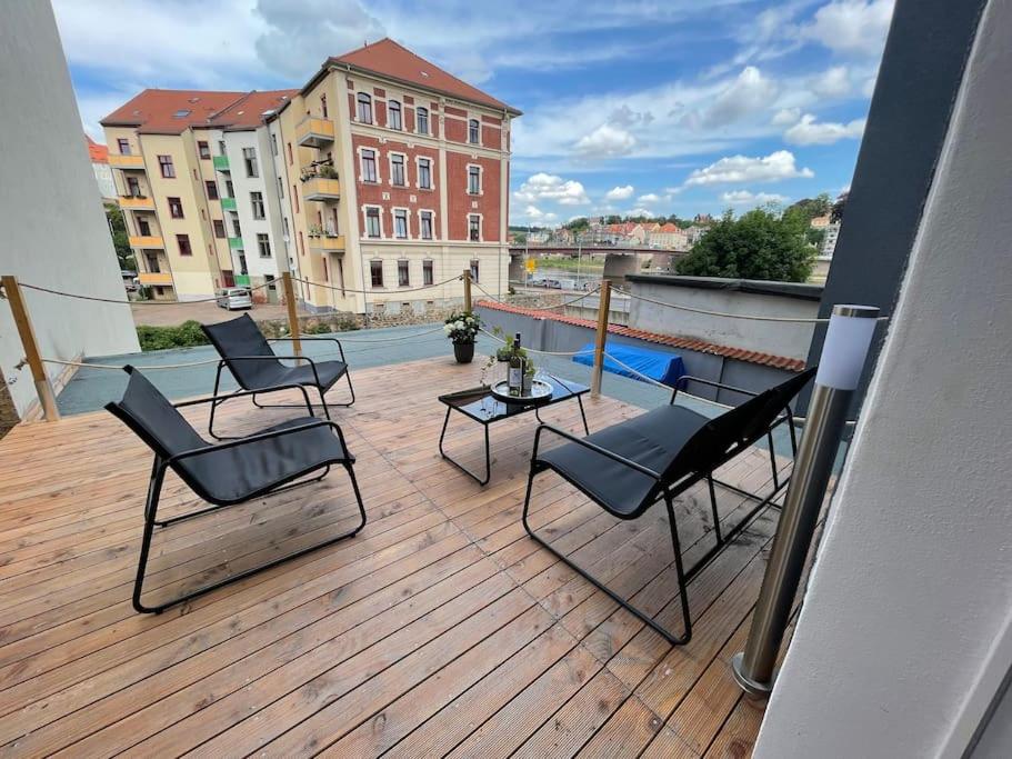 a deck with chairs and a table on a balcony at Traumhaftes Meißen-Terrasse mit Burg-und Elbblick in Meißen