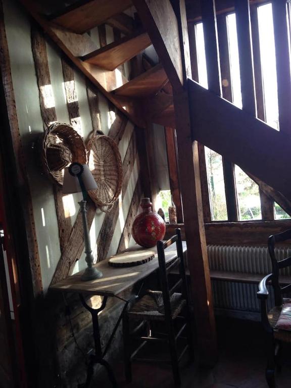 a room with a table with a fan and a window at Gîtes du Manoir de la Porte in Les Authieux-sur-Calonne