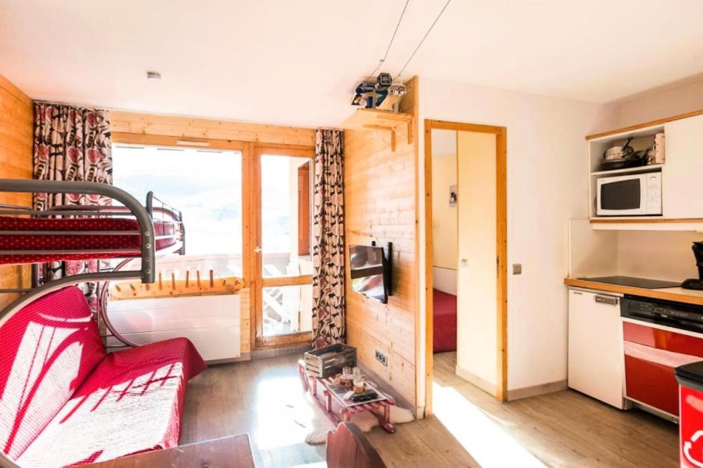 Cette petite chambre comprend des lits superposés et une cuisine. dans l'établissement Résidence Les Temples du Soleil - maeva Home - 2 Pièces 5 Personnes Sélection MAE-1252, à Val Thorens