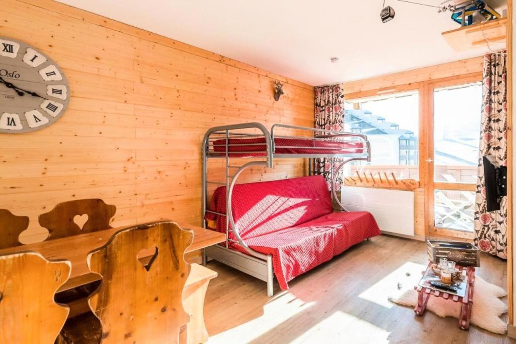 a bedroom with a bunk bed and a clock on the wall at Résidence Les Temples du Soleil - maeva Home - 2 Pièces 5 Personnes Sélect 52 in Val Thorens