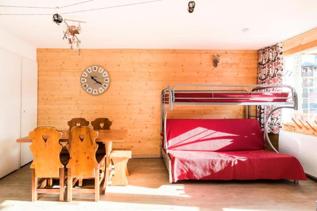 a bedroom with a bunk bed and a table and chairs at Résidence Les Temples du Soleil - maeva Home - 2 Pièces 5 Personnes Sélect 52 in Val Thorens