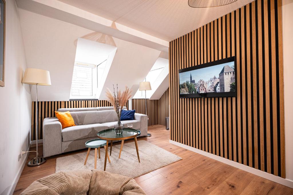 ein Wohnzimmer mit einem Sofa und einem TV an der Wand in der Unterkunft Moderne T2 Centre Sauna Wifi Home office Netflix in Straßburg