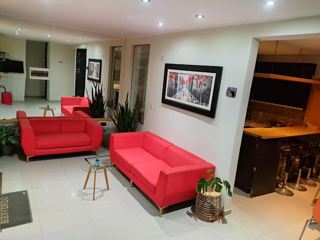 a living room with two red couches and a table at Hotel Kallma Adventures in Ica