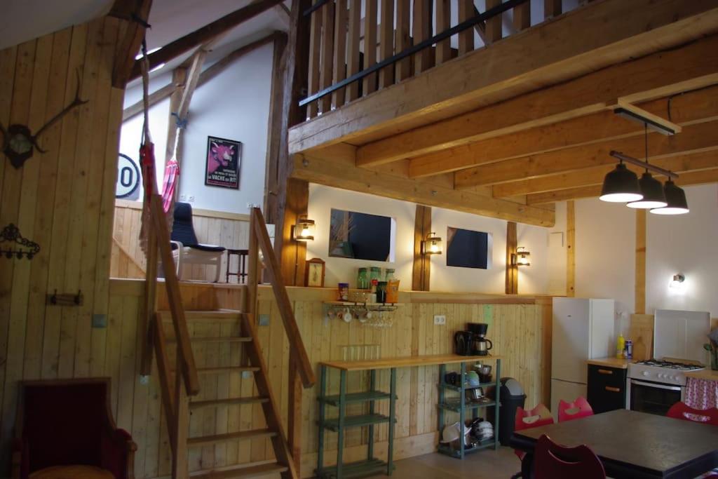 Habitación con escalera de madera en una casa en Loft les Noies Parrons, gîte aux milles étangs en Mélisey