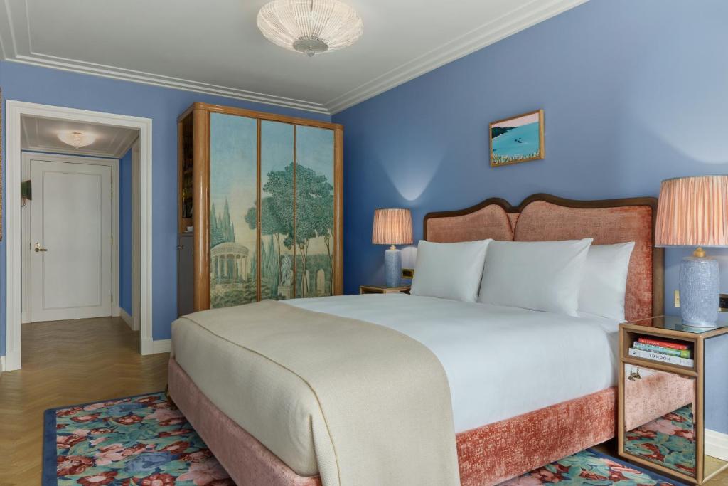 a bedroom with a large bed with blue walls at Broadwick Soho in London