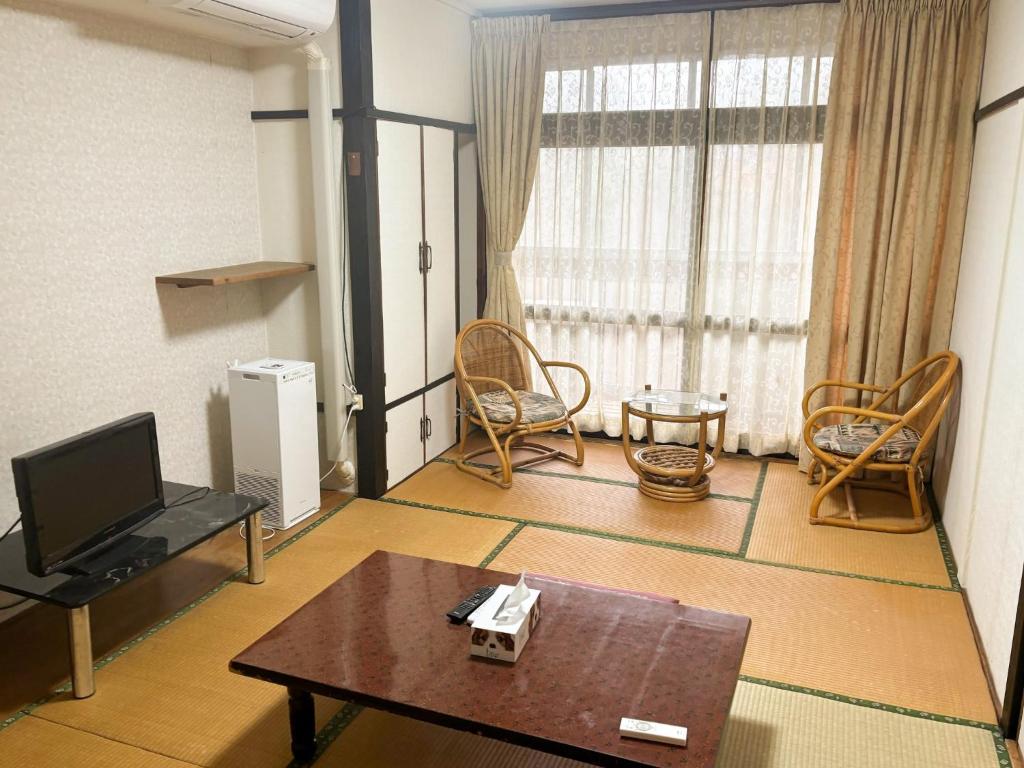 a living room with a tv and a table and chairs at Eco Hotel Yunokosou - Vacation STAY 99596v in Minamata