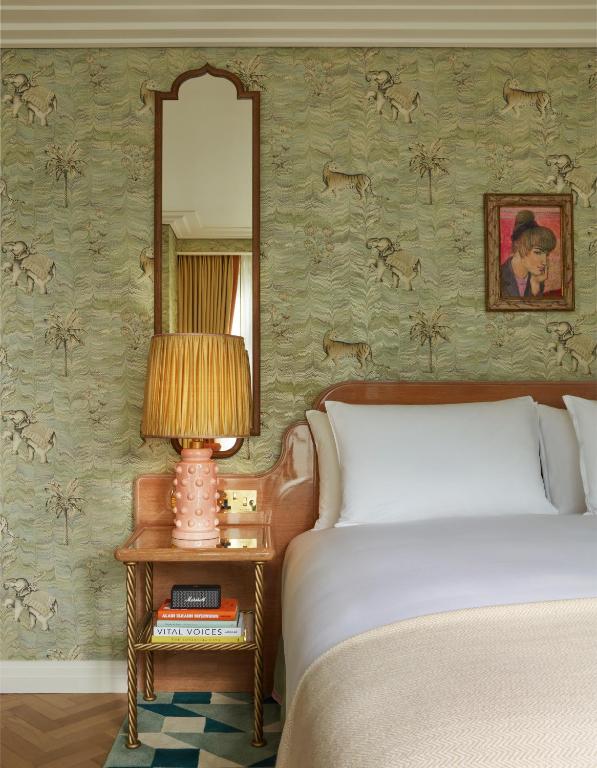 a bedroom with a bed and a table with a lamp at Broadwick Soho in London