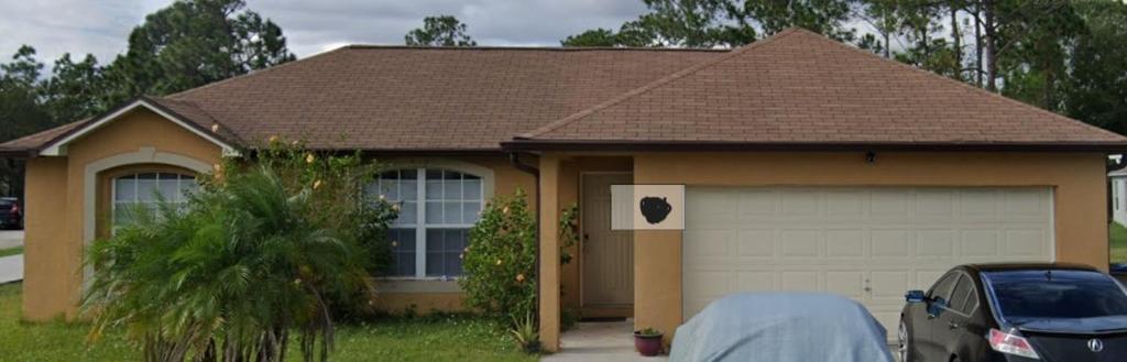 a house with a car parked in front of it at Comfy room and more in Poinciana