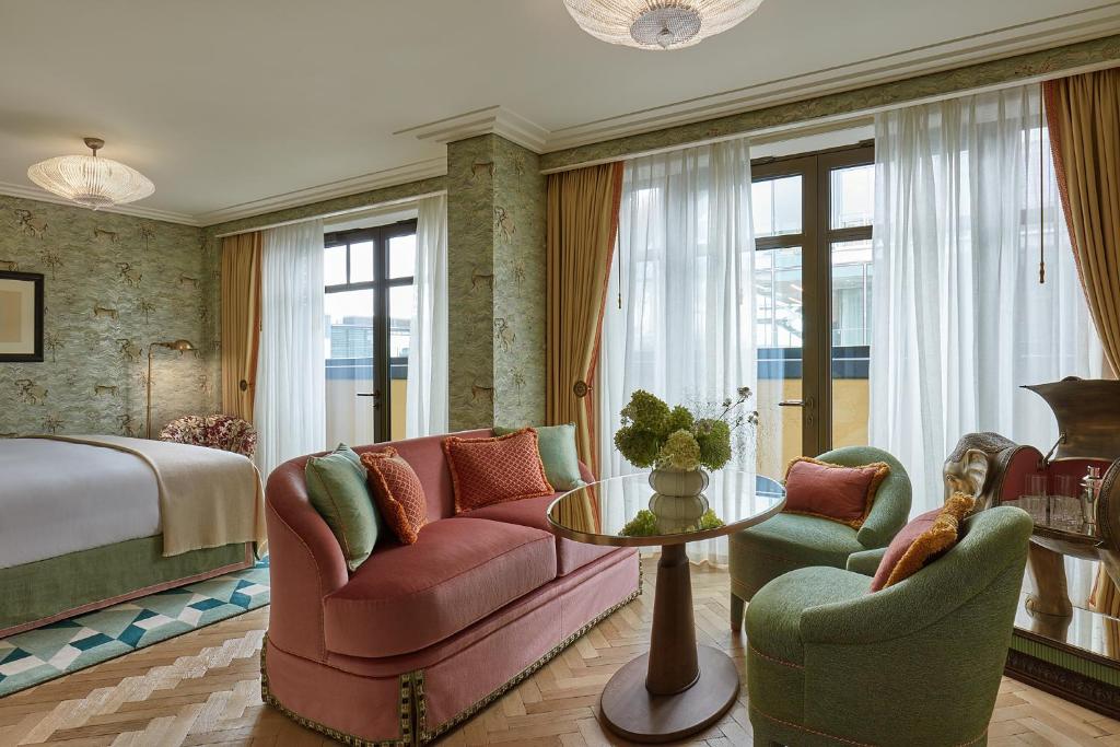 a hotel room with a couch and chairs and a bed at Broadwick Soho in London