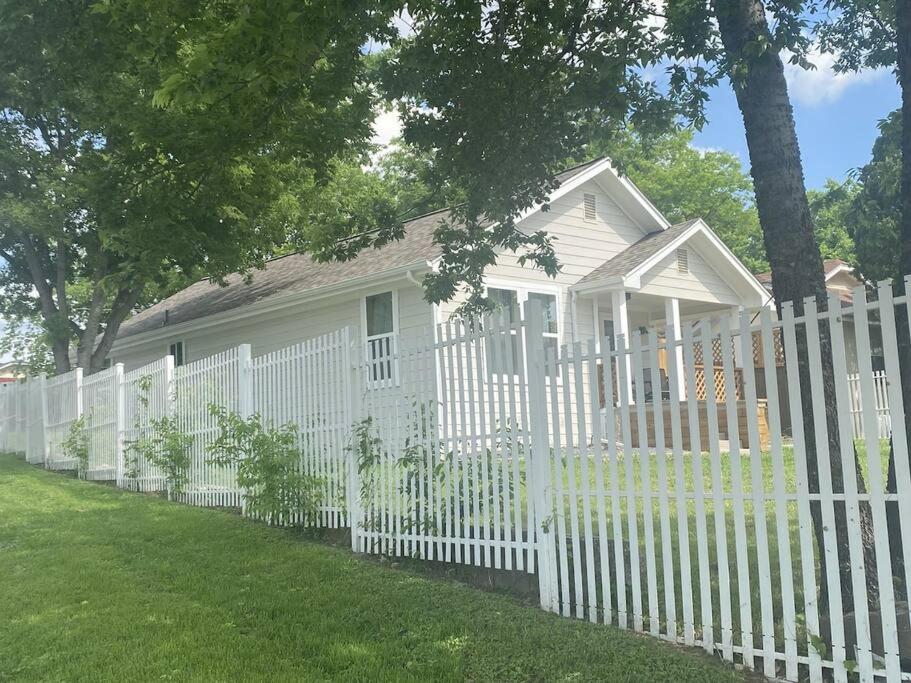 einen weißen Zaun vor einem weißen Haus in der Unterkunft StockYards! Less than 4 minutes-Sleeps 8-Lee House in Fort Worth