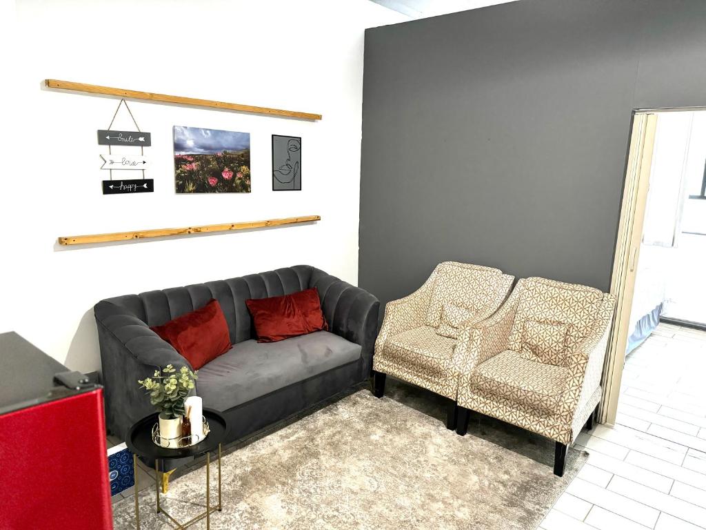- un salon avec un canapé et une chaise dans l'établissement Tranquil Living on Maboneng, à Johannesbourg