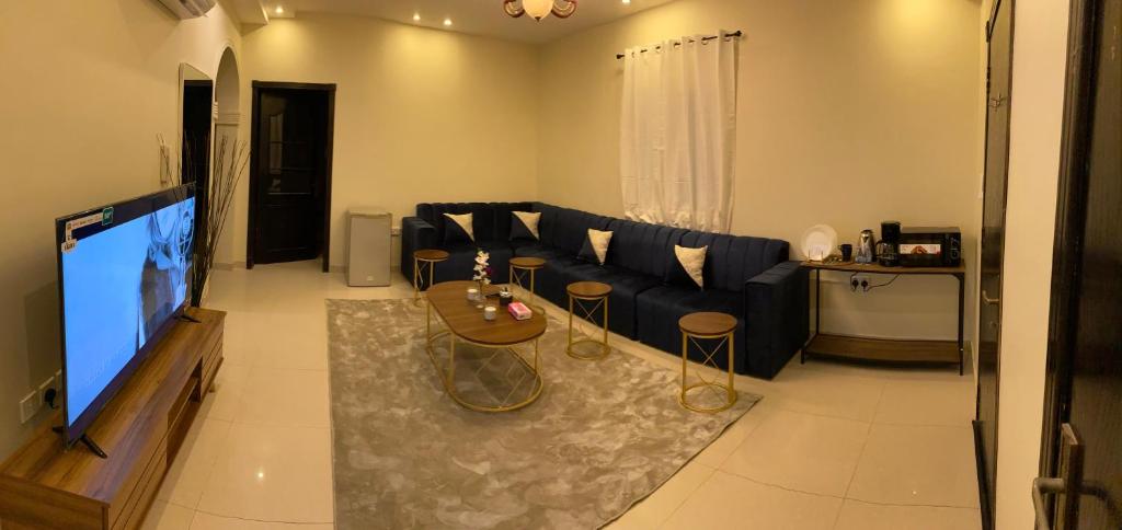 a living room with a blue couch and a tv at شقه بصالة انيقة وغرفة نوم . in Al Khobar