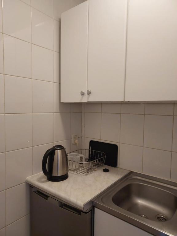 a kitchen with a sink and a tea kettle on a counter at Однокімнатна квартира Варшава in Warsaw