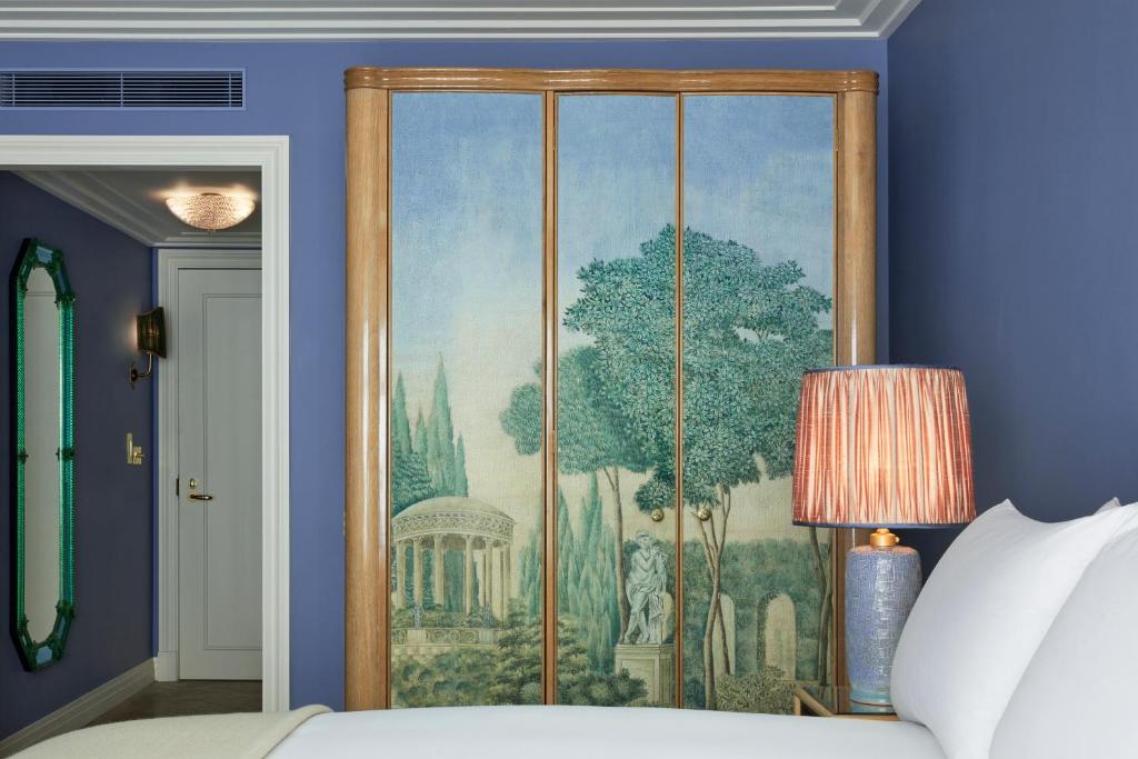 a painting on a blue wall in a bedroom at Broadwick Soho in London